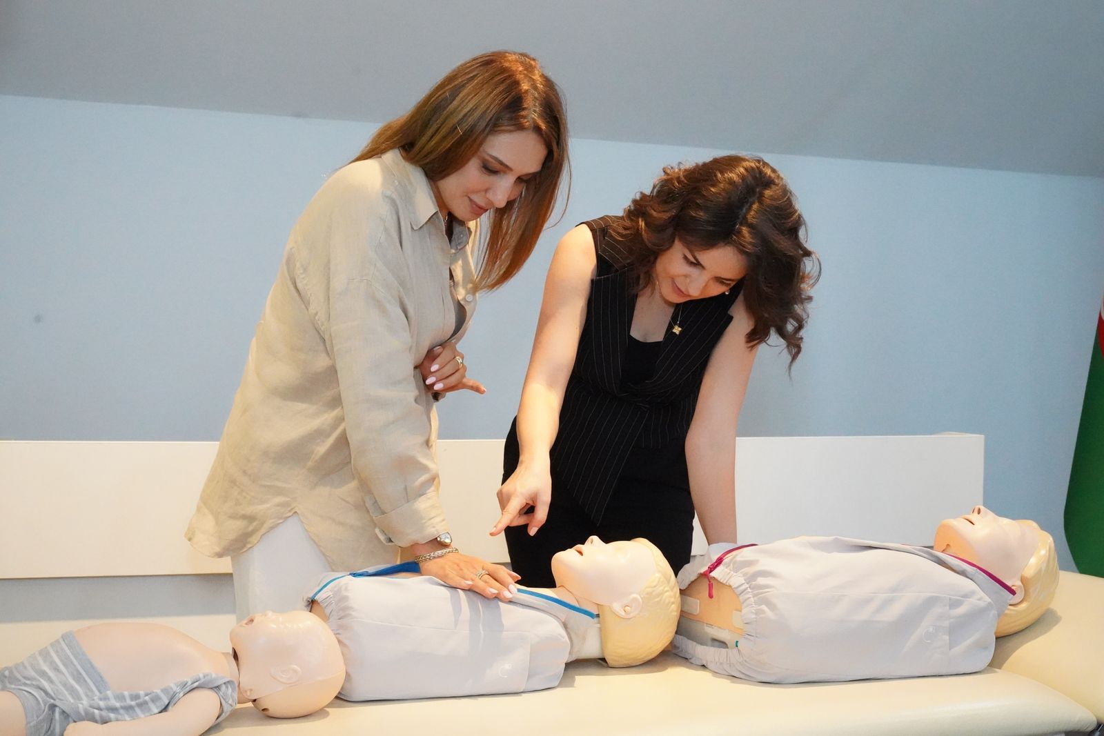 Zwei Teilnehmerinnen üben im Kombikurs gemeinsam die Herzdruckmassage an Trainingspuppen